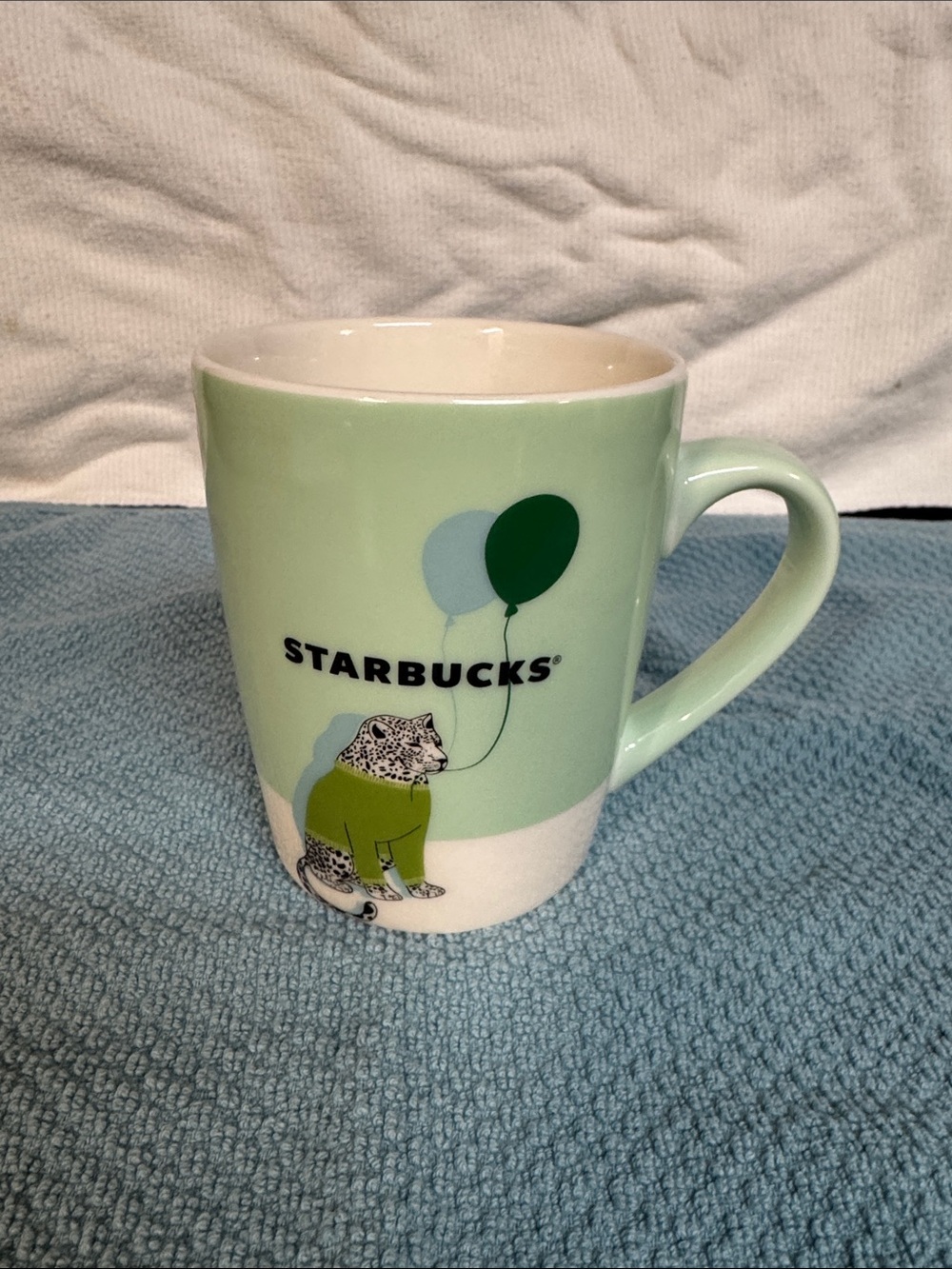 Starbucks 10oz 2020 Coffee Mug with a leopard in a green sweater holding balloon